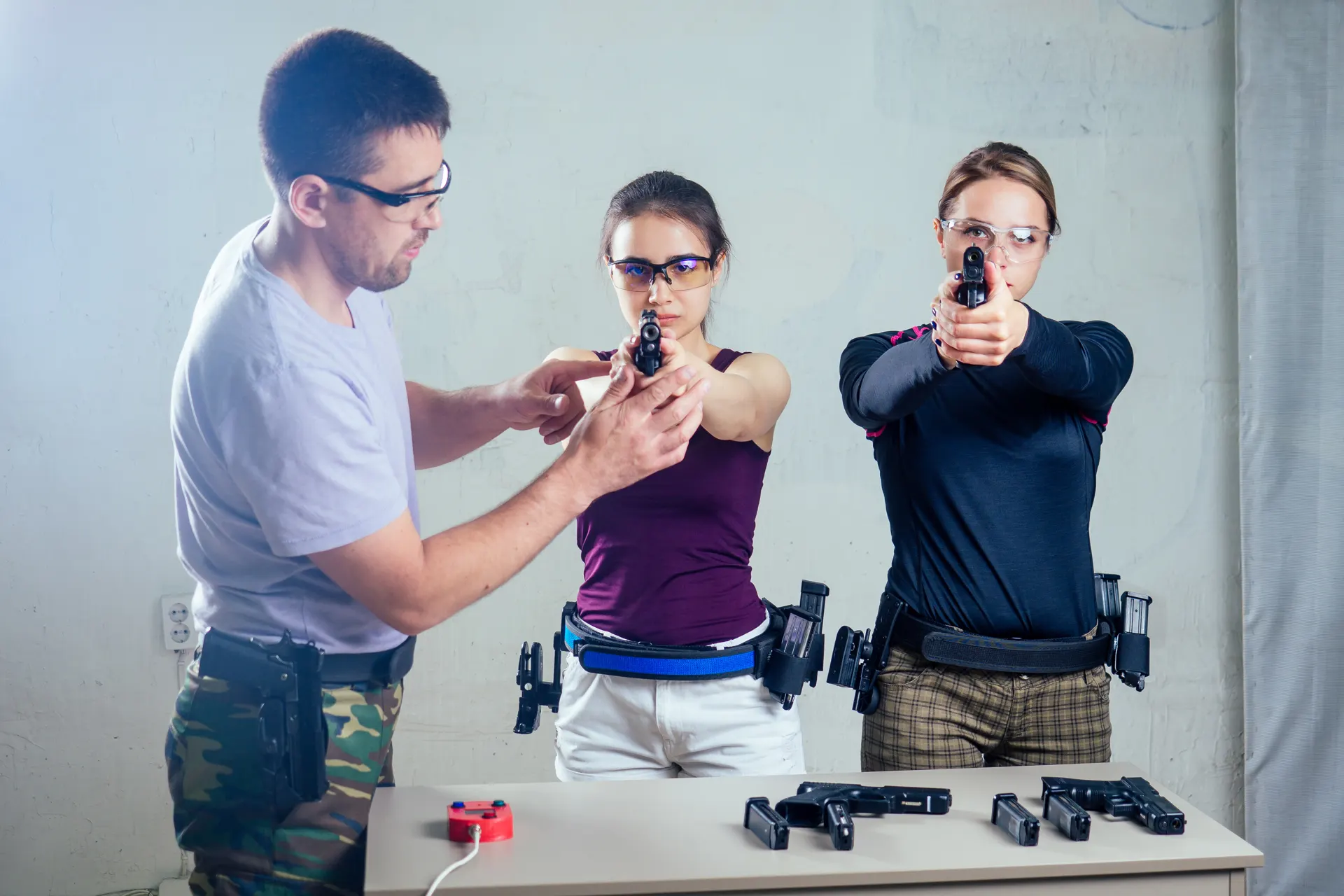 Ausbilder korrigiert zwei Schützinnen an der Kurzwaffe, Ausbildung zur verantwortlichen Aufsichtsperson