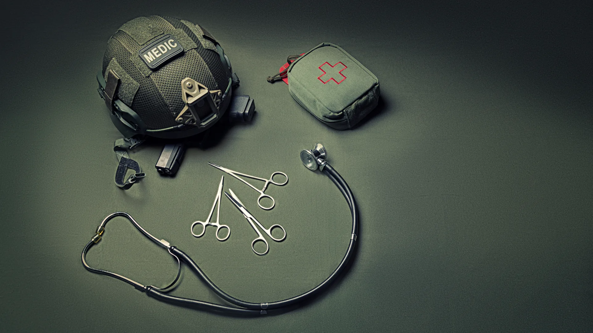 Helm mit Medic-Kennzeichnung, Erste-Hilfe-Tasche und medizinisches Besteck, taktische Einsatzmedizin